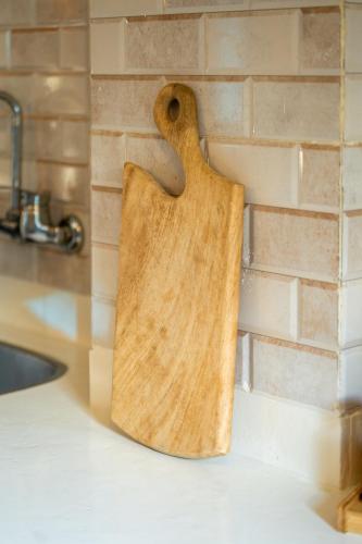 a wooden cutting board hanging on a kitchen wall at Umbi Chalet in Dahab