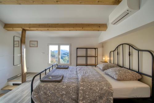 a bedroom with a large bed and a window at Cottage les Marjoris Tanneron in Tanneron
