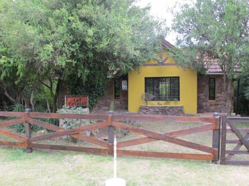 塞拉纳镇Cabaña Los Pololos的一栋门前有木栅栏的房子