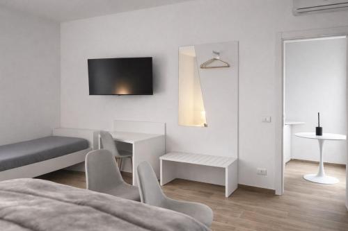 un soggiorno bianco con tavolo e sedie di Cìvitas Suite ApartHotel a Catania