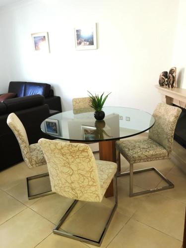 a glass table and chairs in a living room at São Martinho do Porto Beach Apartment in São Martinho do Porto