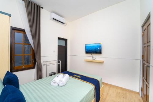 a room with two beds and a tv on the wall at Semenrante Living By ARBA in Solo