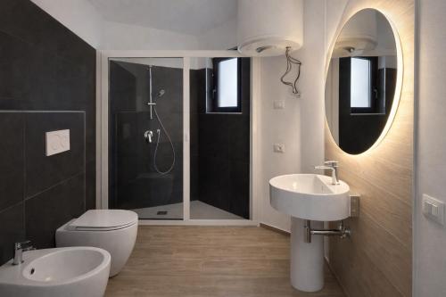 un bagno con wc, lavandino e doccia di Cìvitas Suite ApartHotel a Catania