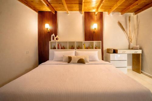 a bedroom with a large white bed with two pillows at Umbi Chalet in Dahab