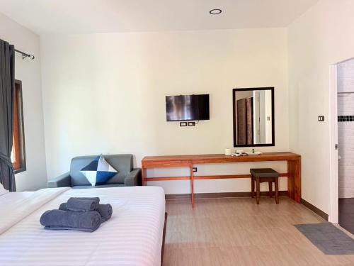 a bedroom with a bed and a desk and a mirror at BuaSawan Villa Koh Lanta in Ban Not (1)