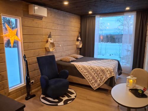 a bedroom with a bed and a chair at Arctic River View in Rovaniemi