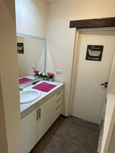 a bathroom with a sink and a mirror at Las Cortaderas House in Trancas