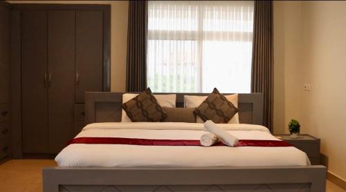 ein Schlafzimmer mit einem großen Bett mit einem großen Fenster in der Unterkunft Ghanas Finest The Reach in East Legon