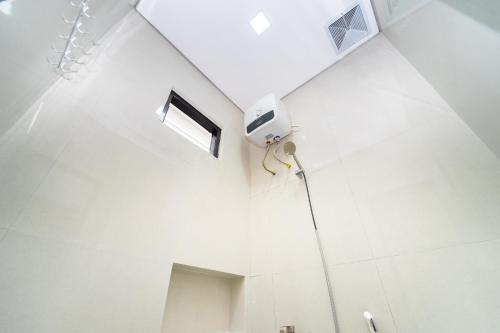 a white bathroom with a shower and a fan at Semenrante Living By ARBA in Solo