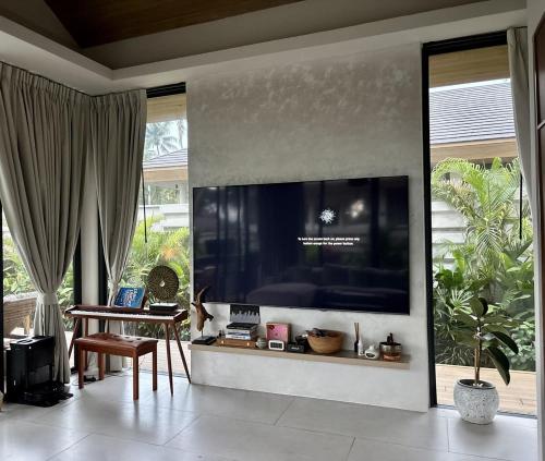 een woonkamer met een grote televisie aan de muur bij Tropical villa in Ko Pha Ngan