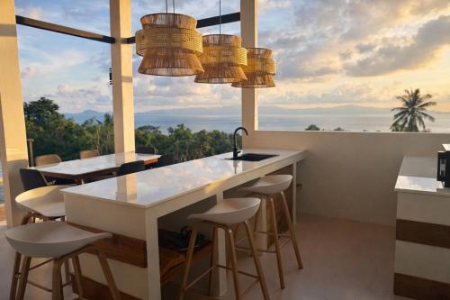 une cuisine avec un comptoir avec des tabourets et une grande fenêtre dans l'établissement NAHA Villa Sea View Koh Phangan, à Baan Tai