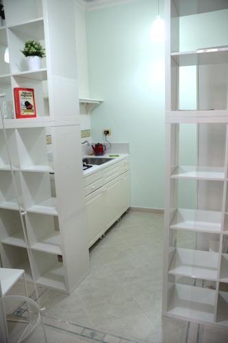 a white kitchen with white shelving in a room at Luciano And Son in Campobasso