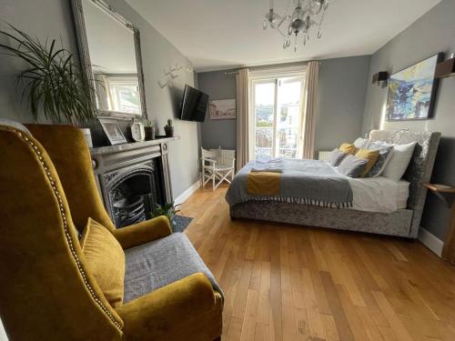 a bedroom with a bed and a couch and a fireplace at Millpool House in Dartmouth