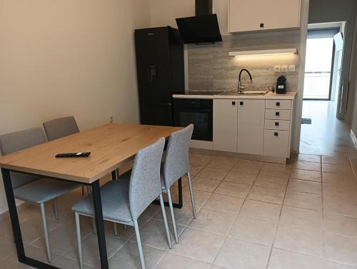 una cucina con un tavolo di legno con sedie e un lavello di Urban Mountain House a Karpenision