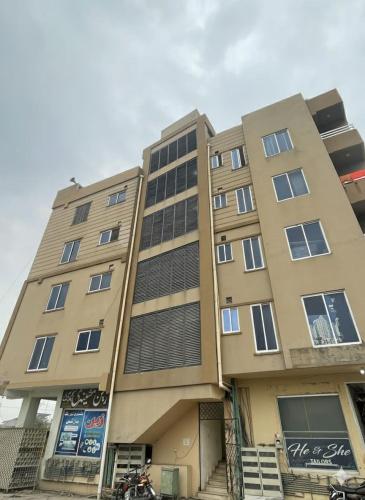 a tall building with a motorcycle parked in front of it at SerenityINn in Islamabad