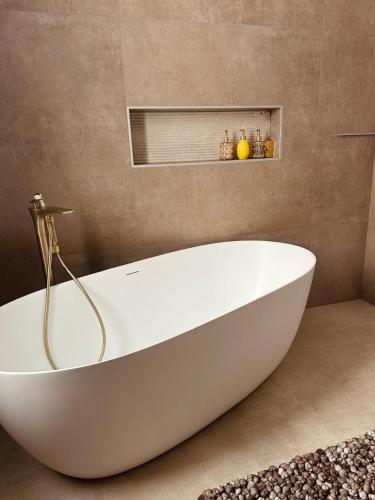 a large white bath tub in a bathroom at Villa Elmiso Sarajevo in Sarajevo