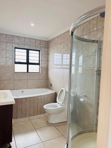 a bathroom with a tub and a toilet and a shower at Sanlou - Southport in Port Shepstone