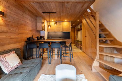 eine Küche und ein Wohnzimmer in einer Blockhütte mit einer Couch in der Unterkunft Troillet 11 in Méribel