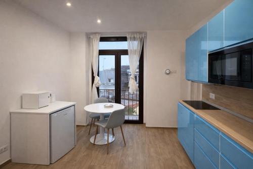 a kitchen with a small table and a table and chairs at Cìvitas Suite ApartHotel in Catania