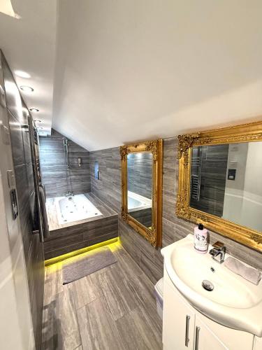a bathroom with a tub and a sink and a mirror at Luxury Apartment in Blackpool