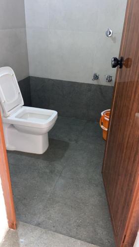 a bathroom with a white toilet and a door at Amber Mount Resorts in Kanthalloor