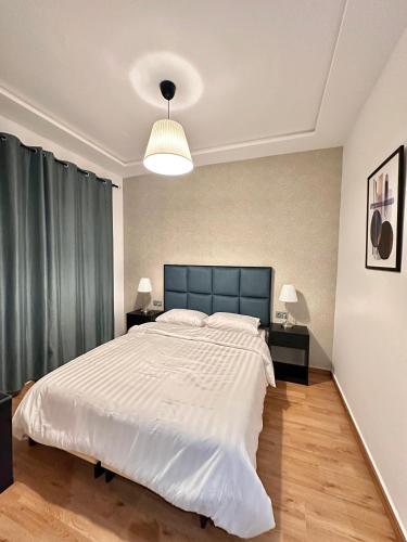 a bedroom with a large white bed and two lamps at Spacious apartment in Tétouan