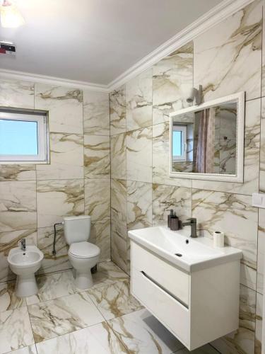 a bathroom with a sink and a toilet and a mirror at Будинок в Мукачево in Mukacheve