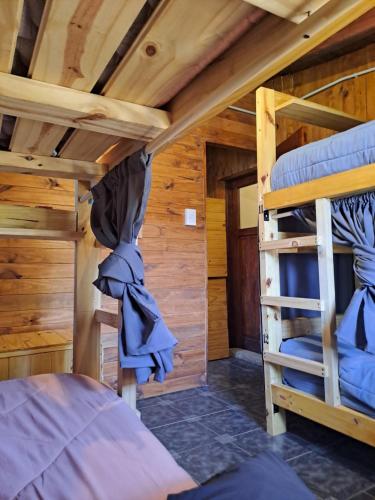 una camera da letto con due letti a castello in una cabina di HOSTEL EL LIMON a El Bolsón