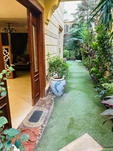 New cairoViolet Villas Area的花园里，门旁摆着一瓶插在花瓶里的植物。