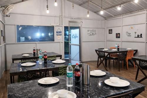 una sala da pranzo con tavoli, sedie e bottiglie di soda di Hotel Madhushree Morning Moon In - Restaurant & Free Parking Facilities - Best Premium Hotel In Bhimtal a Bhimtal