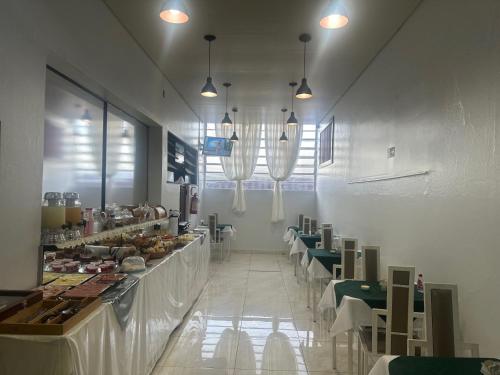 a dining room with tables and chairs and a buffet at Hotel Ype de São Carlos in São Carlos