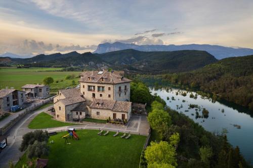 an aerial view of a large house on a lawn next to a river at Casas Pirineo, Ainsa in Aínsa