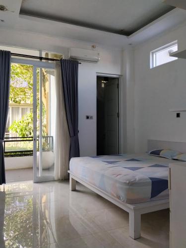 a bedroom with a bed and a large window at RADJIMIN Guesthouse in Adi Sutjipto