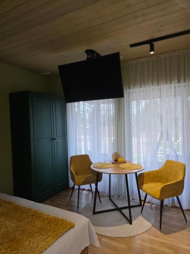 een slaapkamer met een tafel en stoelen en een bed bij Tähetee Majake in Palometsa