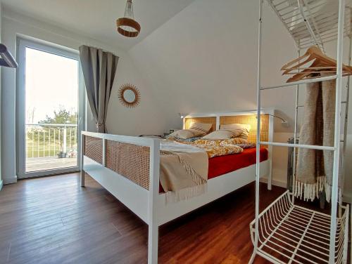 a bedroom with a white bunk bed and a window at Ferienhaus Zur Oie in Bresewitz