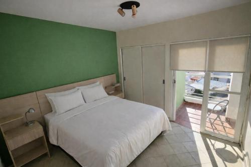 ein Schlafzimmer mit einem weißen Bett und einer grünen Wand in der Unterkunft Nice Full Apartment Downtown Salta in Salta