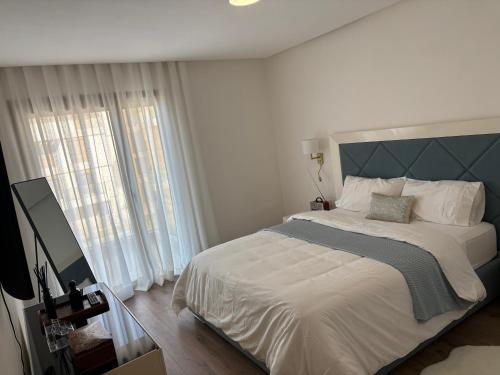 een slaapkamer met een groot bed en een groot raam bij Carrousel Atlantic View in Rabat