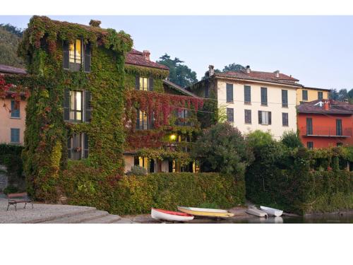 貝拉焦的住宿－佩斯卡洛公寓，常春藤覆盖的楼房,水中有船