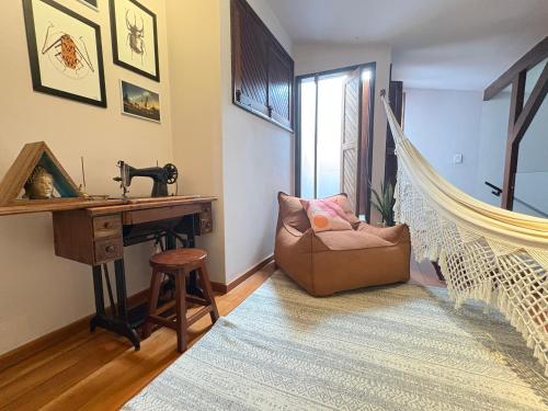een woonkamer met een hangstoel en een bureau bij Descubra a Casa Felicidade em Belém! Climatizada, com sala ampla, 2 quartos, mezanino e Wi-Fi veloz. Localização central perto de atrações e gastronomia. Viva a Amazônia com conforto exclusivo. Reserve já sua experiência inesquecível! in Curro Velho