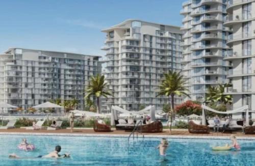 a group of people in a swimming pool with apartment buildings at Nasma Luxury stays- Sophisticated Interior near Hayat Beach in Ras al Khaimah