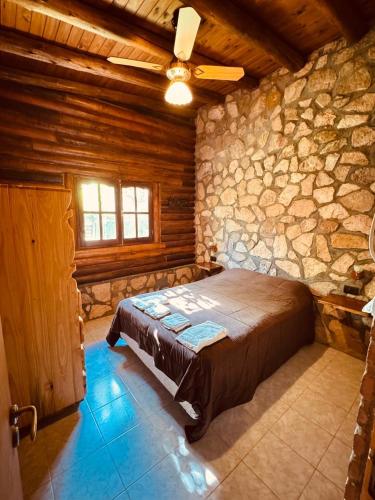 a bedroom with a bed and a stone wall at Guathemoc cabañas in Panaholma