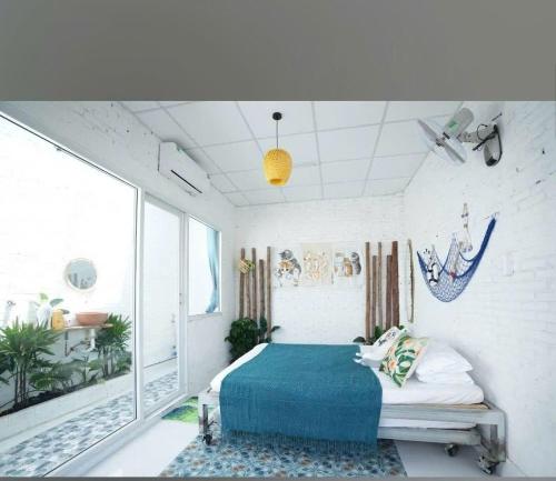 een slaapkamer met een bed met een blauwe deken bij The peace home in Tấn Tài