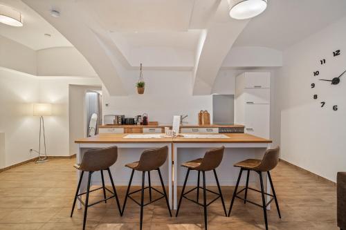 a kitchen with a counter with four stools at dreamfactory Residence - Eastside in Vienna