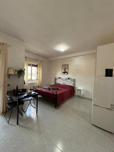 a bedroom with a bed and a table and a refrigerator at Residenza Anagnina in Rome