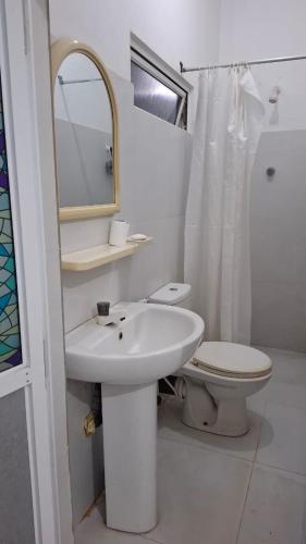 a bathroom with a sink and a toilet and a mirror at Priya Villa Homestay in Jaffna