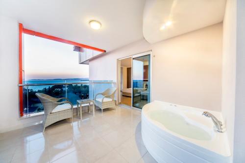un bagno con vasca, tavolo e sedie di Lonicera Resort & Spa Hotel - Ultra All Inclusive ad Avsallar