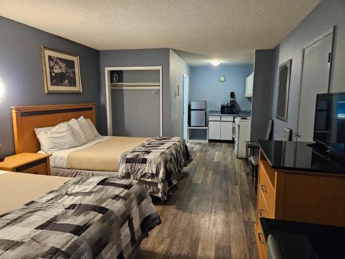 a hotel room with two beds and a flat screen tv at Metro Inn in Victoria