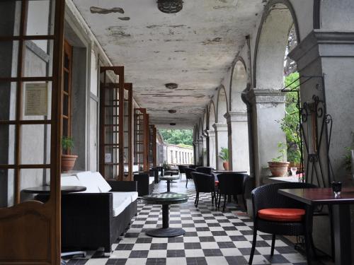 ein Restaurant mit Tischen und Stühlen und einem karierten Boden in der Unterkunft APOSTROPHE Chambres d'Hôtes in Montolieu