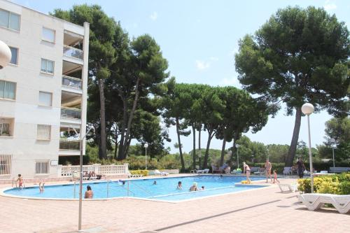 a swimming pool with people in it next to a building at For A Stay Cala Dorada in Salou