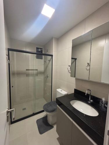 ein Badezimmer mit Dusche, Waschbecken und Toilette in der Unterkunft Apartamento 03 quartos Pajucara mcz in Maceió